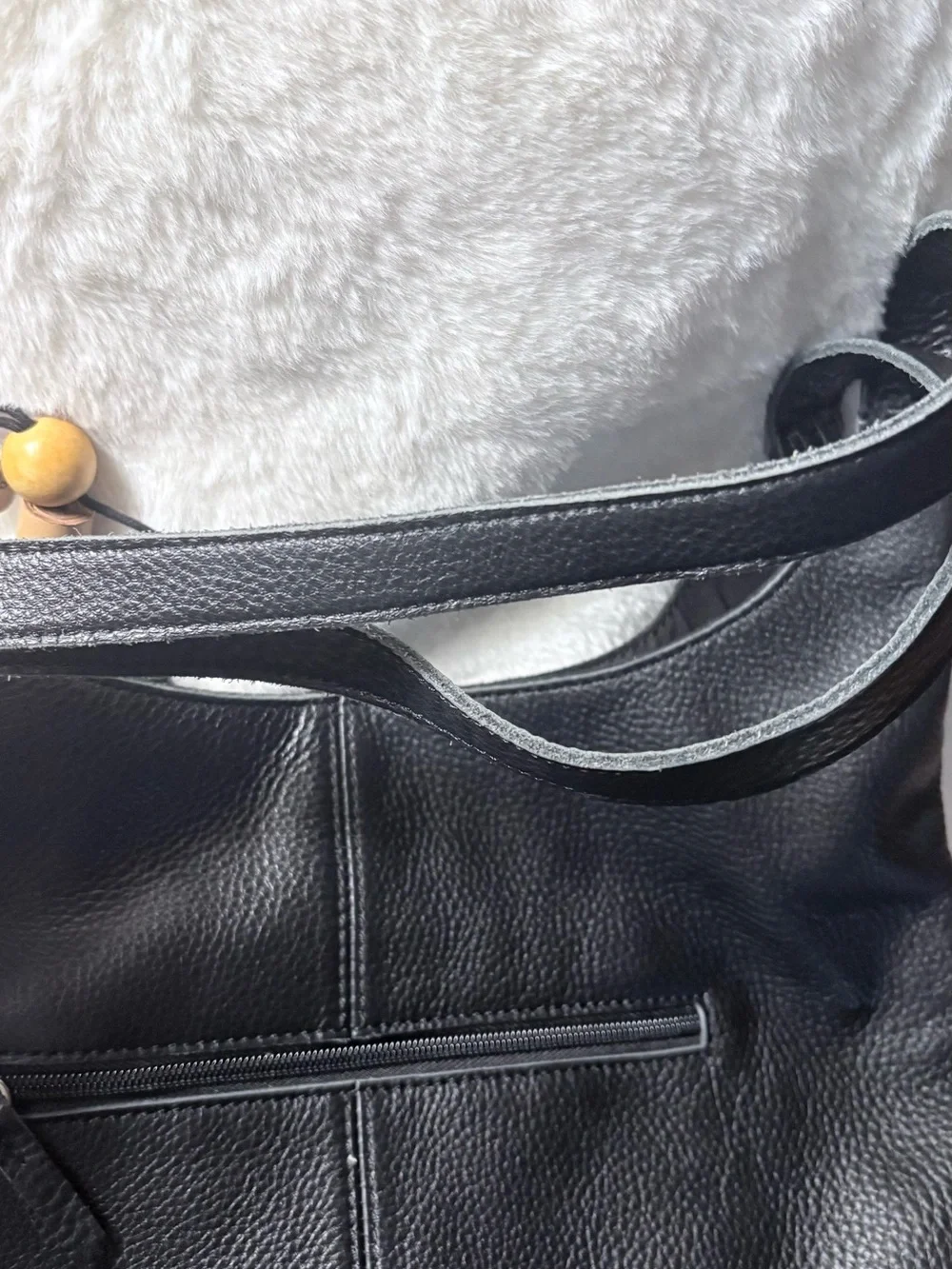 The Sak Black Leather Shoulder Bag with Tan Tassel Charm